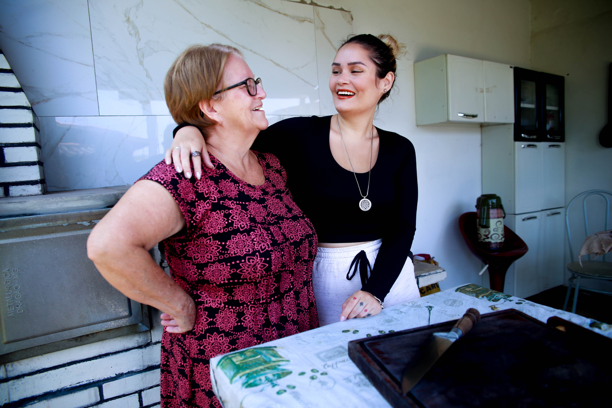 iStock-1469339642 Happy mother and daughter talk while cooking in a rustic kitchen