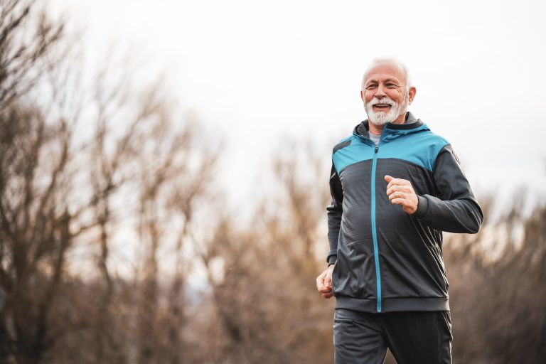Um idoso pratica corrida num parque